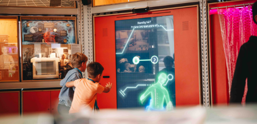 Docent geeft uitleg over machine aan kinderen
