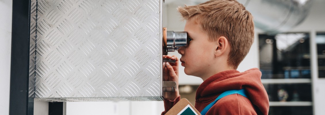Docent geeft uitleg over machine aan kinderen