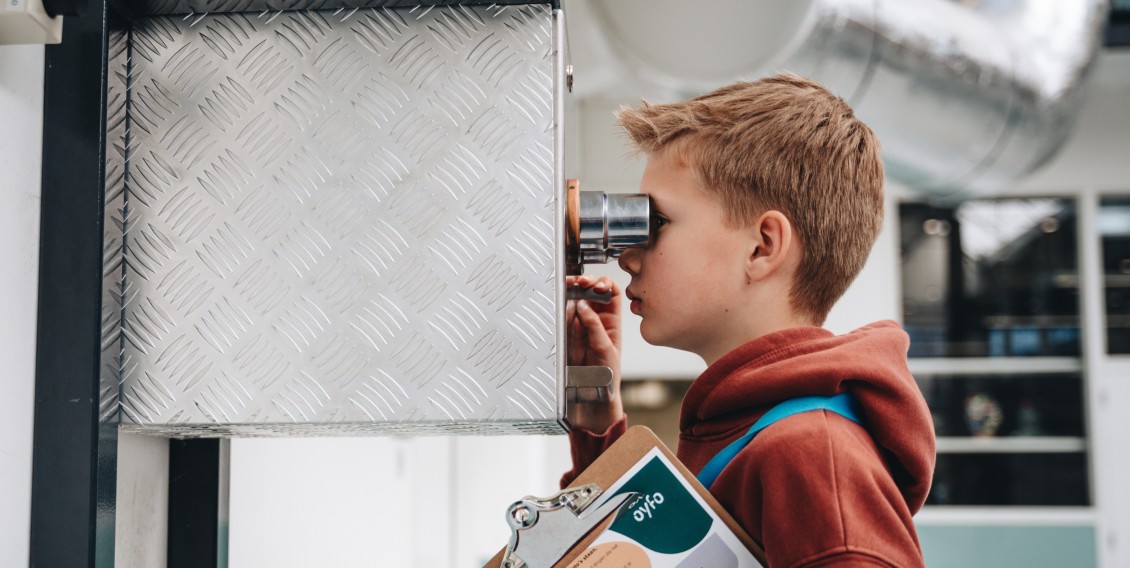 Docent geeft uitleg over machine aan kinderen