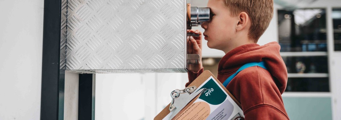 Docent geeft uitleg over machine aan kinderen